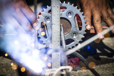 Close-up of man working on metal chain