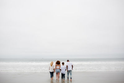 Family walking in water at beach