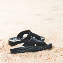 Close-up of shoes on sand