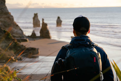 Rear view of man looking at sea against sky