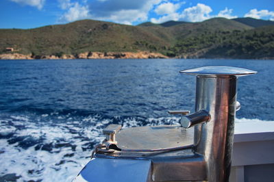 Closeup on ship cord crank, rope holder against blue sea