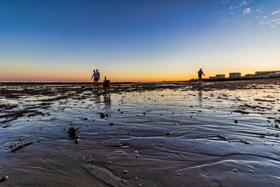 Silhouette man on beach against sky during sunset