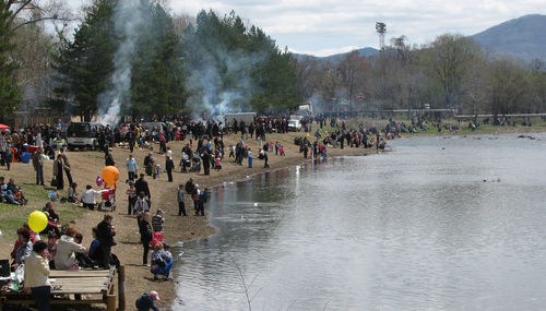 Group of people on shore against trees