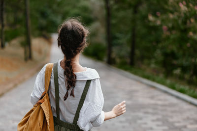 Rear view of woman standing on footpath