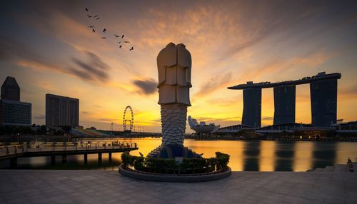 Gazebo in city against sky during sunset