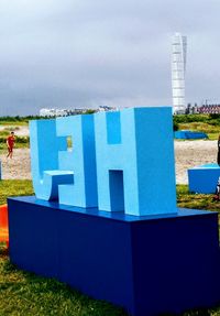 Hooded beach chairs against blue sky