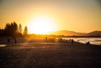 Silhouette of people at beach during sunset