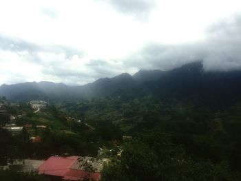 Scenic view of mountains against cloudy sky