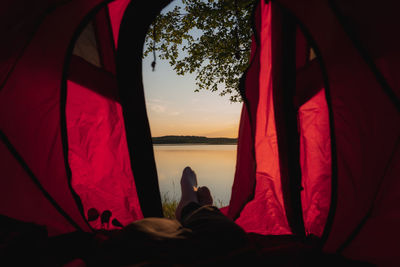 Rear view of woman relaxing in tent