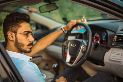 Man looking away while sitting in car