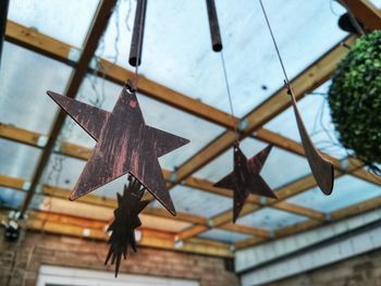 Low angle view of decorations hanging on roof against building