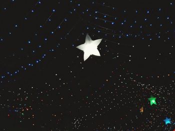 Low angle view of illuminated lighting equipment at night