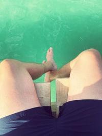 Low section of woman sitting in swimming pool