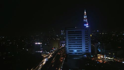 Illuminated skyscrapers against sky at night