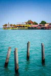 Pier over sea against clear blue sky