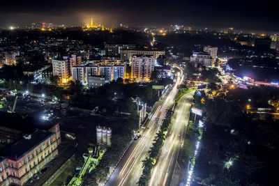 High angle view of illuminated city street amidst buildings at night