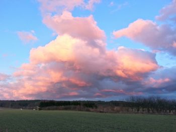 Scenic view of field against cloudy sky