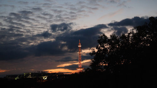 Silhouette of factory against sky during sunset