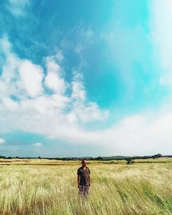 Man standing on field against sky