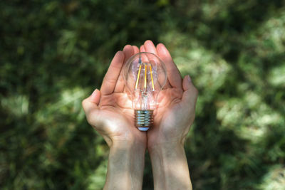 Close-up of hand holding light bulb