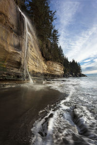 Scenic view of waterfall against sky