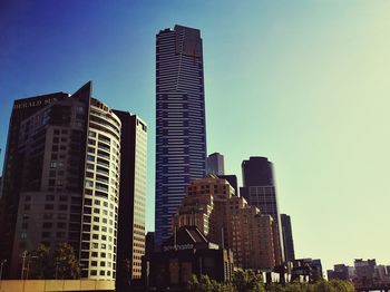 Low angle view of skyscrapers against clear blue sky