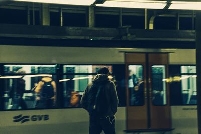 Rear view of woman standing on railroad station platform