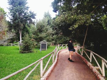 Full length of woman standing by tree at park