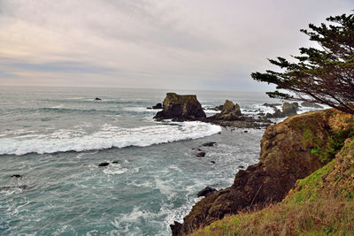 Rock formations on shore against sky