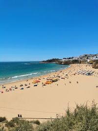 Scenic view of beach against clear blue sky