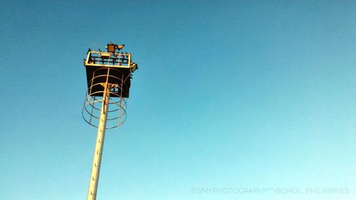 Low angle view of communications tower against blue sky