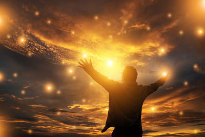 Rear view of man standing against sky during sunset