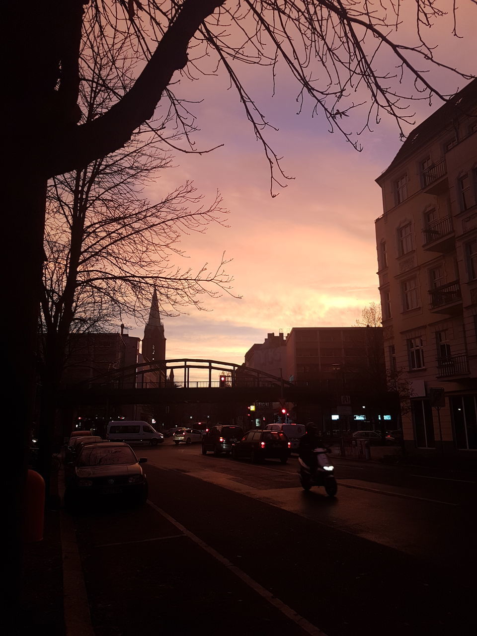 CARS ON STREET IN CITY DURING SUNSET