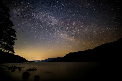 Scenic view of silhouette mountains against sky at night