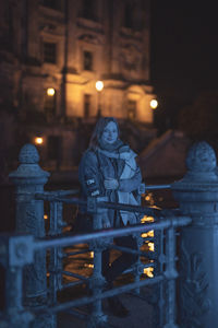 Illuminated statue against building at night during winter