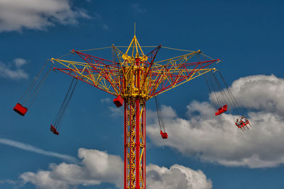 Low angle view of amusement park ride against blue sky