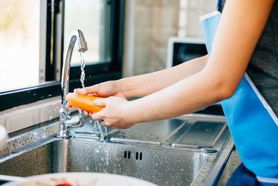 Midsection of man washing hands