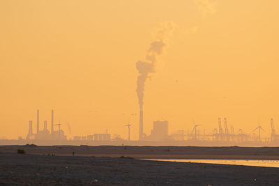 Smoke emitting from chimney against sky