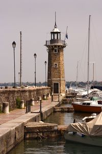 Boats moored at harbor against clear sky