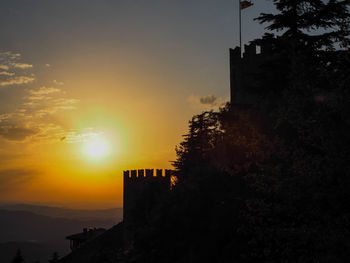 Silhouette buildings against sky during sunset