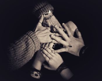 Close-up of couple hands against black background