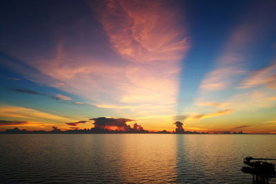 Scenic view of sea against dramatic sky during sunset