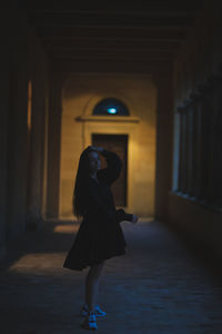 Woman walking in corridor of building