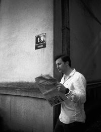 Man looking at camera while standing against wall