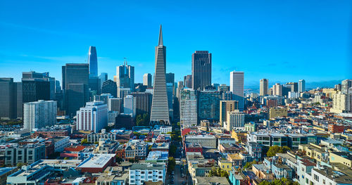 Modern buildings in city against clear blue sky