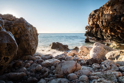 Rocks on beach against sky