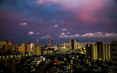 Illuminated buildings in city against sky at night