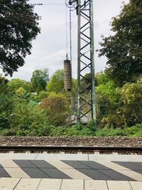 Railroad tracks by trees against sky