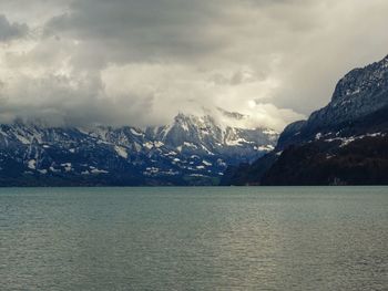 Scenic view of sea and mountains against sky