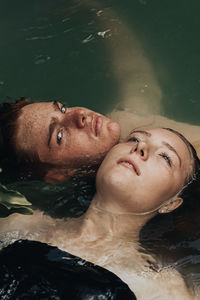 High angle view of couple floating on lake